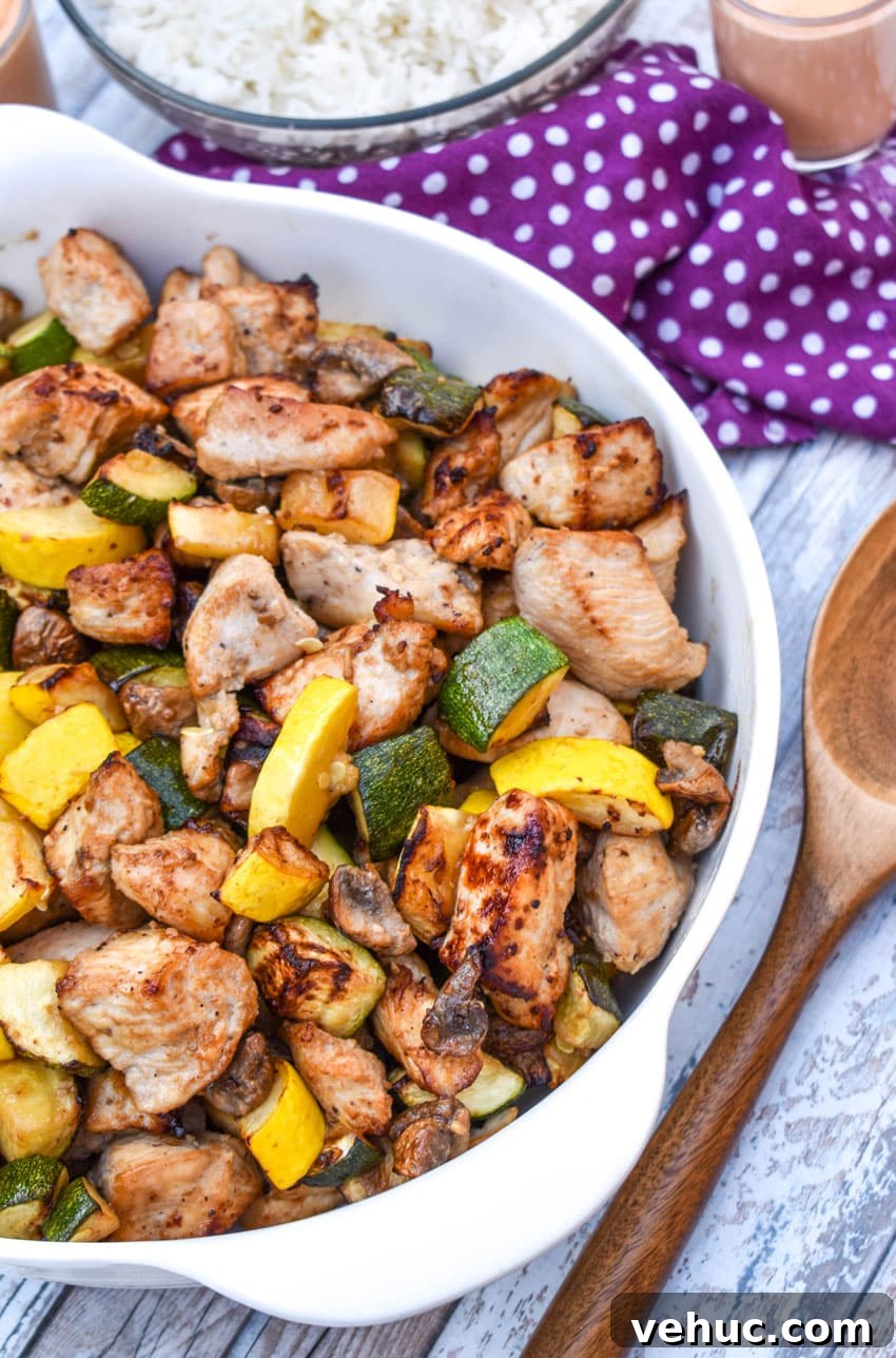 Air Fryer Hibachi-Style Chicken and Vegetables Recipe 7 easy homemade hibachi chicken and vegetables in a white serving bowl with a wooden spoon on the side