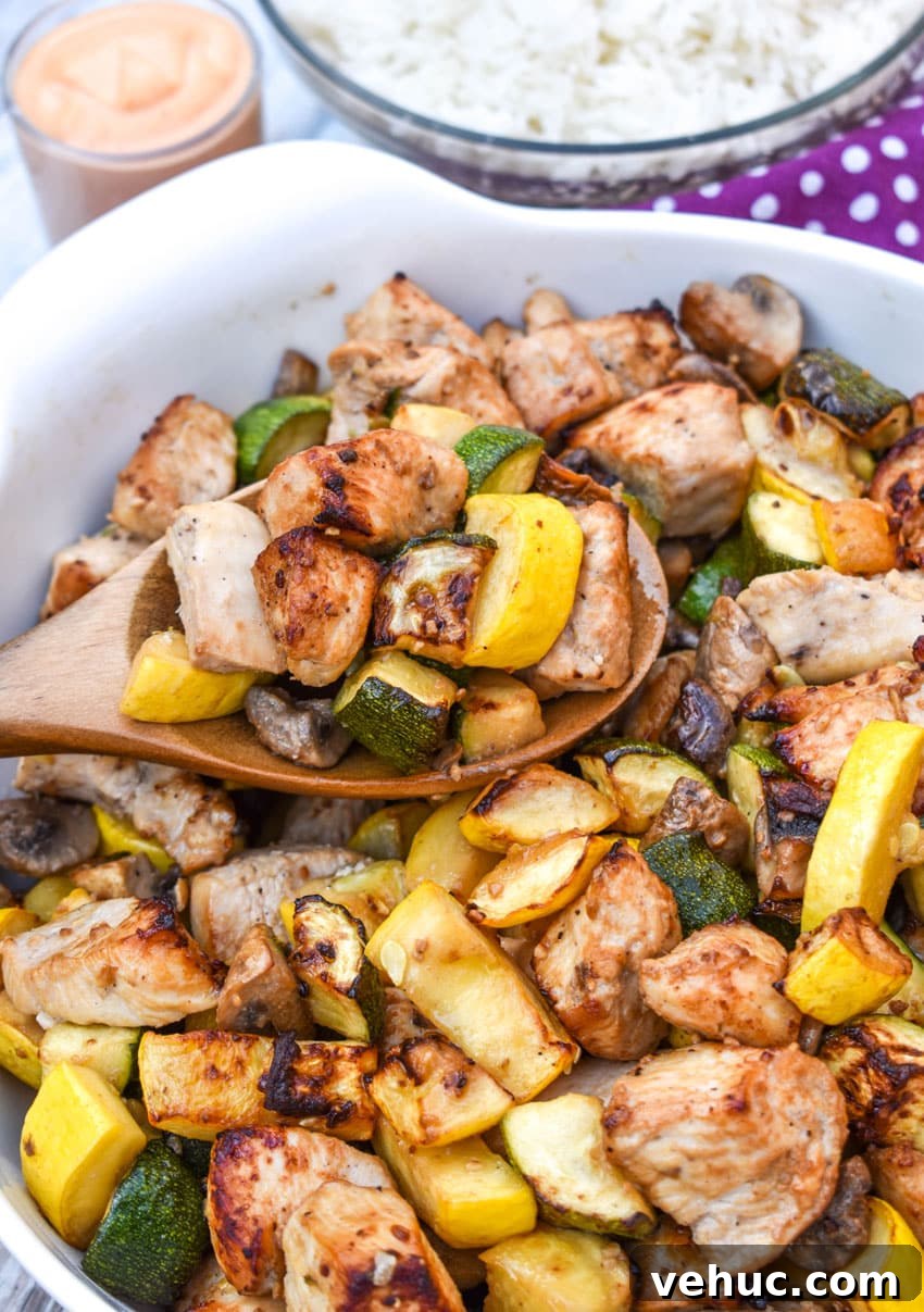 Air Fryer Hibachi-Style Chicken and Vegetables Recipe 8 a wooden spoon scooping easy homemade hibachi chicken and vegetables out of a large white bowl