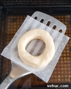 vegan glazed doughnuts step 7 - transferring a doughnut to the oil