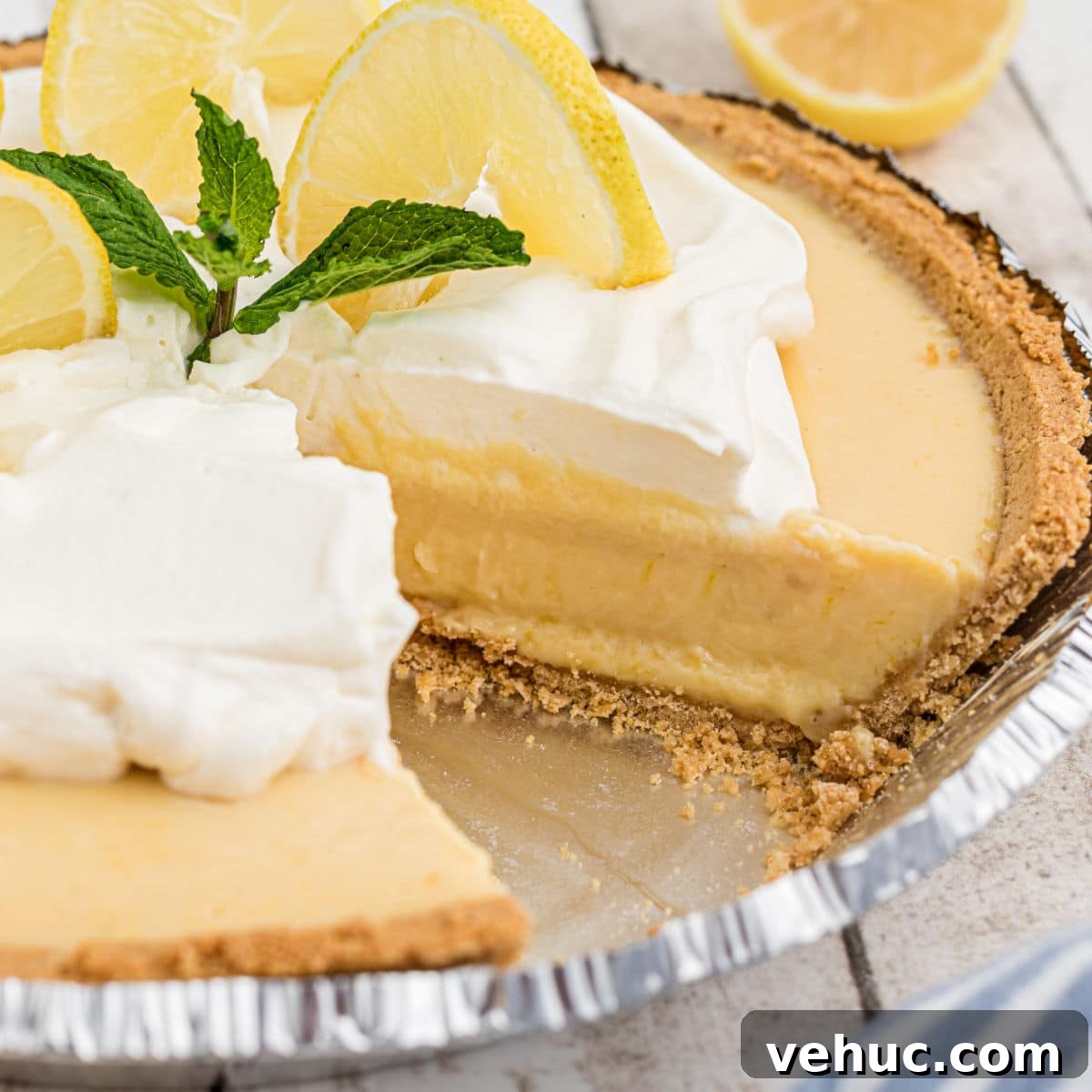 Square cropped shot of the inside of a southern lemon pie with some cream and lemon slices on top.
