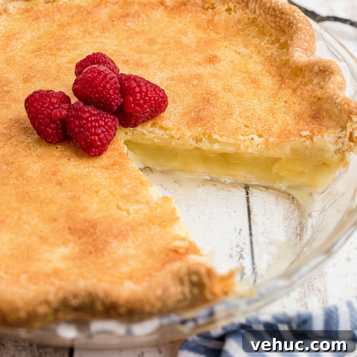Close up shot of a cracker barrel buttermilk pie recipe with a slice taken out of it.