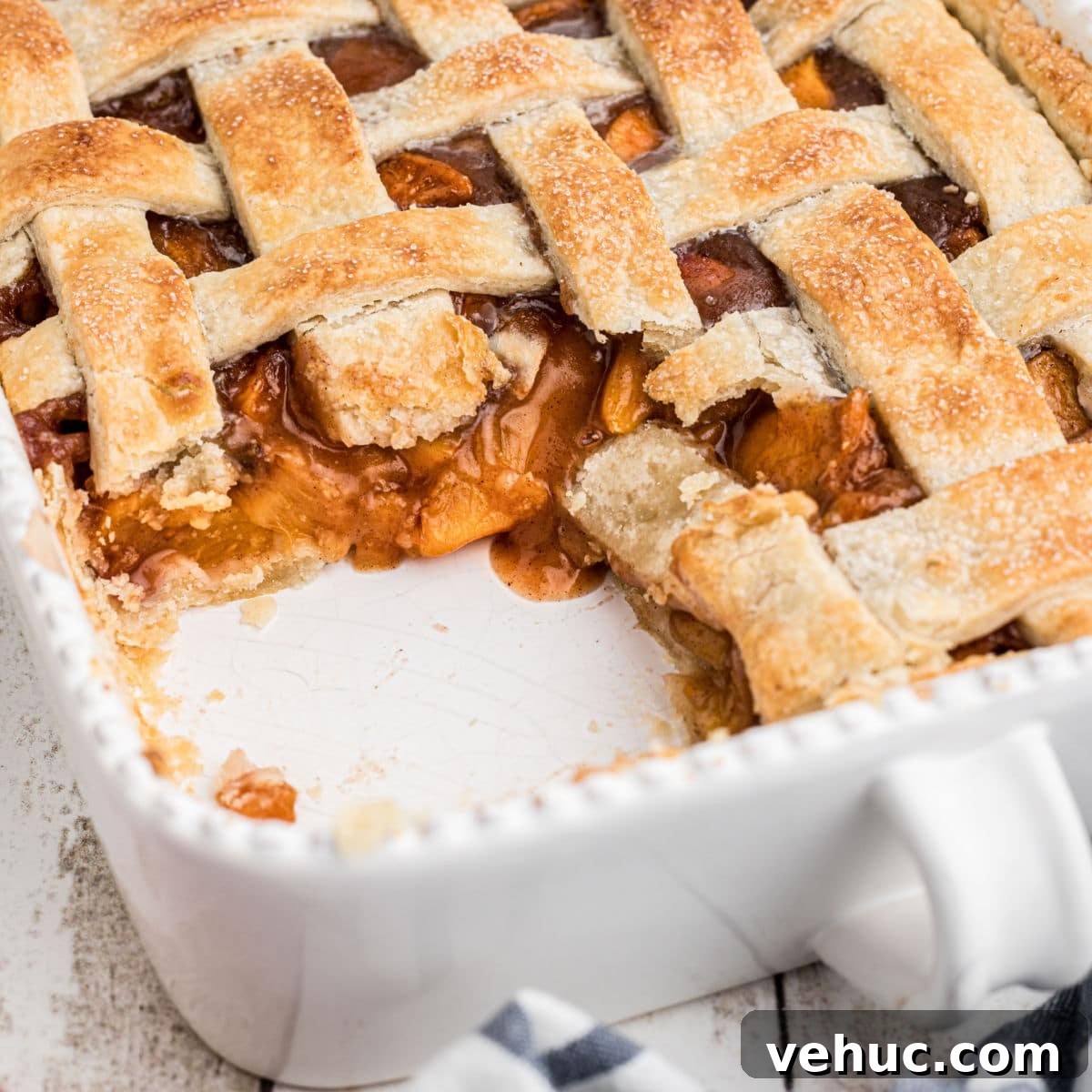 dish with a southern peach cobbler with pie crust, some missing, cropped square.