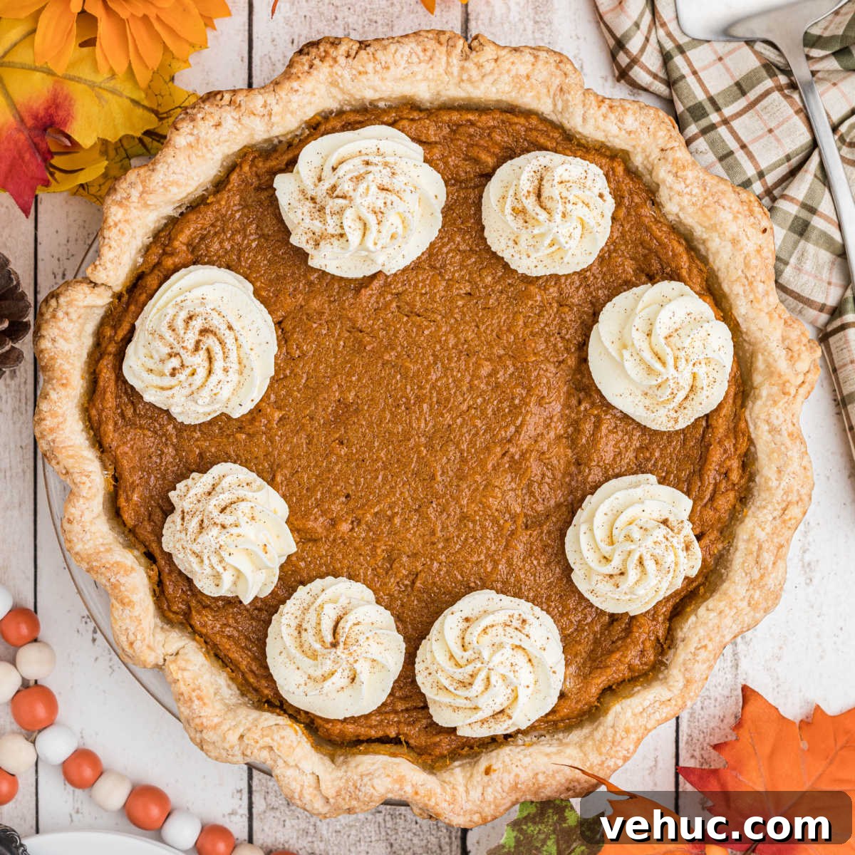 Overhead shot of a sweet potato pie with swirls of cream.
