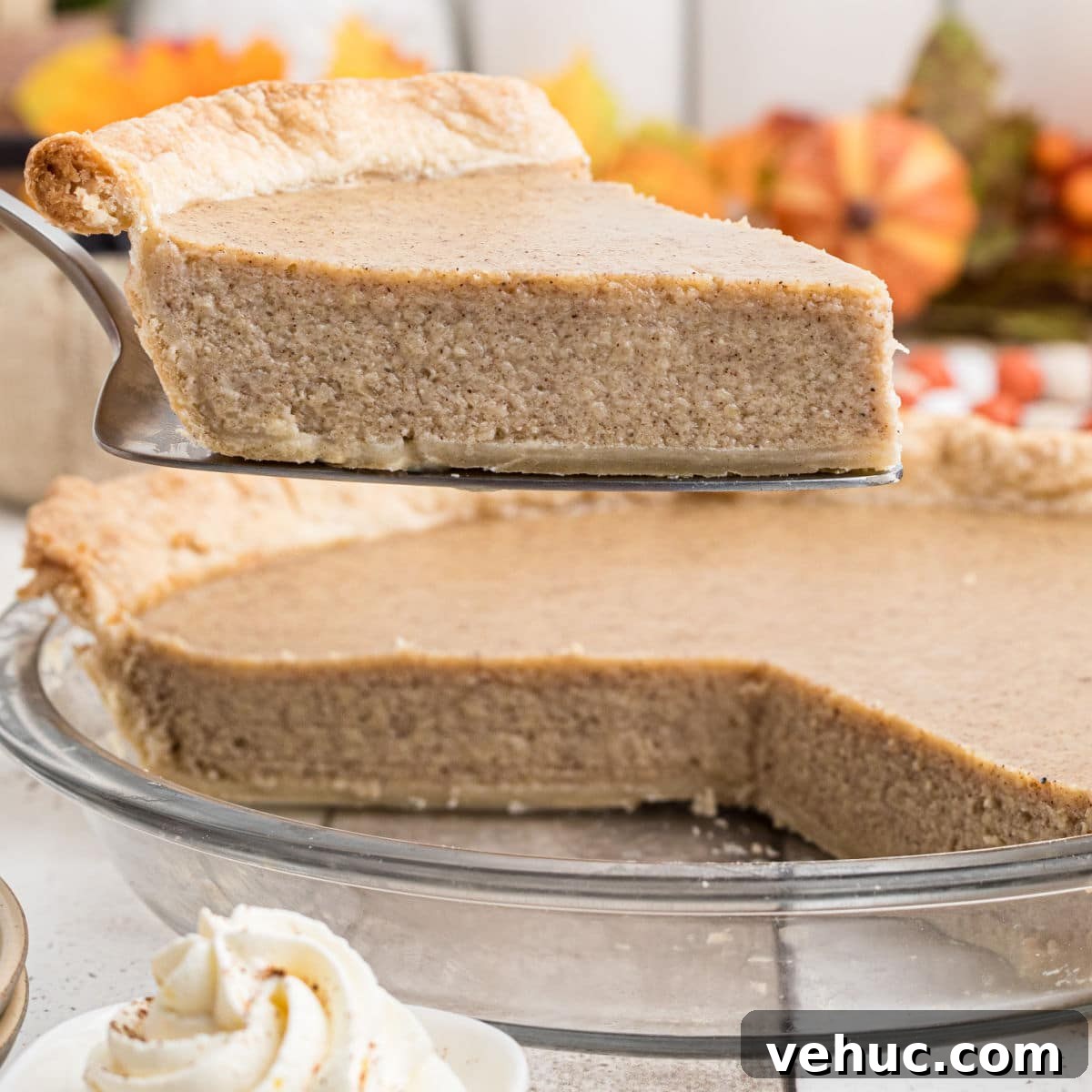 Close up of a slice of white pumpkin pie being taken out of a pie dish.