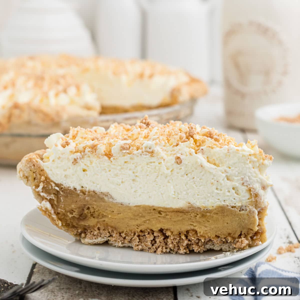 A slice of Amish Peanut Butter Pie on a plate with the pie dish behind.