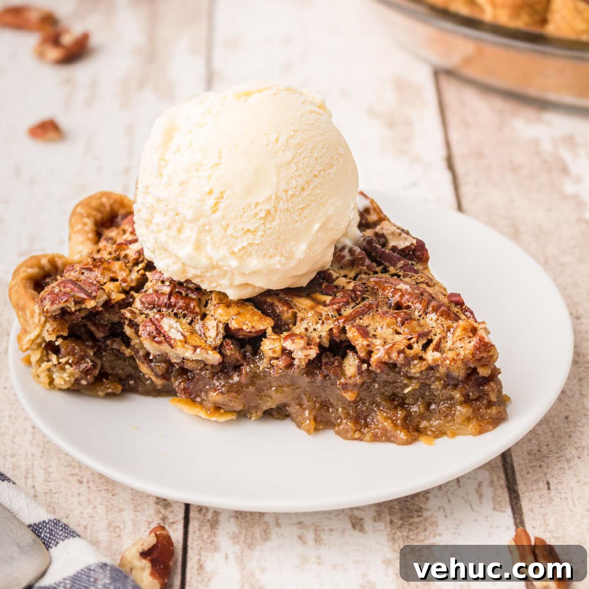 a plate with a slice of pecan pie with a ball of ice cream sitting on top