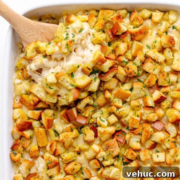 Creamy Cheddar Scalloped Potatoes Recipe 11 Scoop of gouda mac and cheese being lifted from white casserole dish.