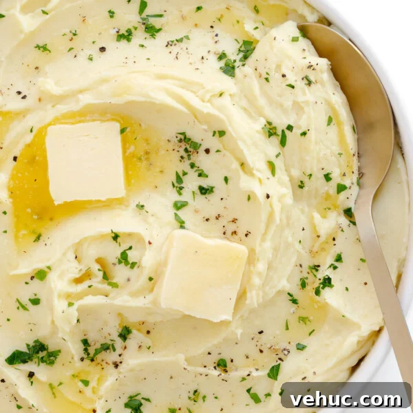 Creamy Cheddar Scalloped Potatoes Recipe 12 Creamy whipped mashed potatoes in a serving bowl with serving spoon.