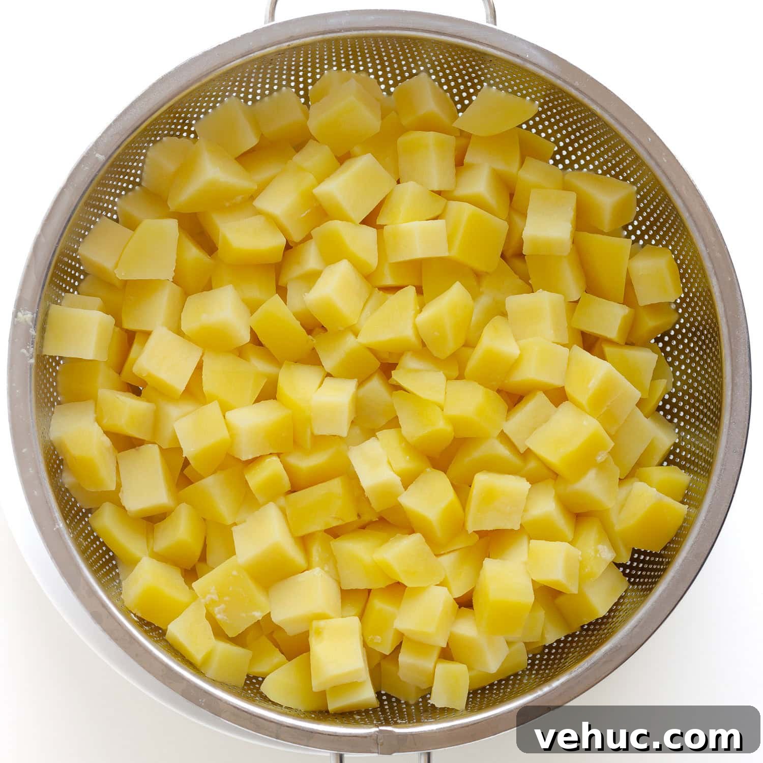 Creamy Cheddar Scalloped Potatoes Recipe 5 Boiled chopped potatoes in stainless steel strainer.