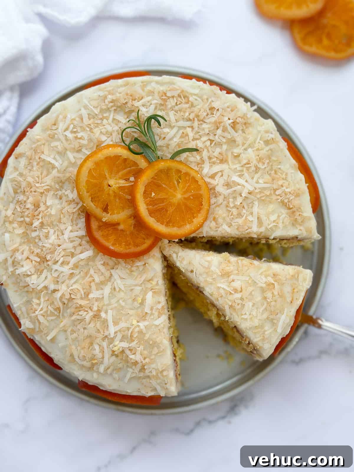 Moist Orange Coconut Cake Recipe with Zesty Glaze 2 a slice of orange coconut cake sliced and the rest whole.