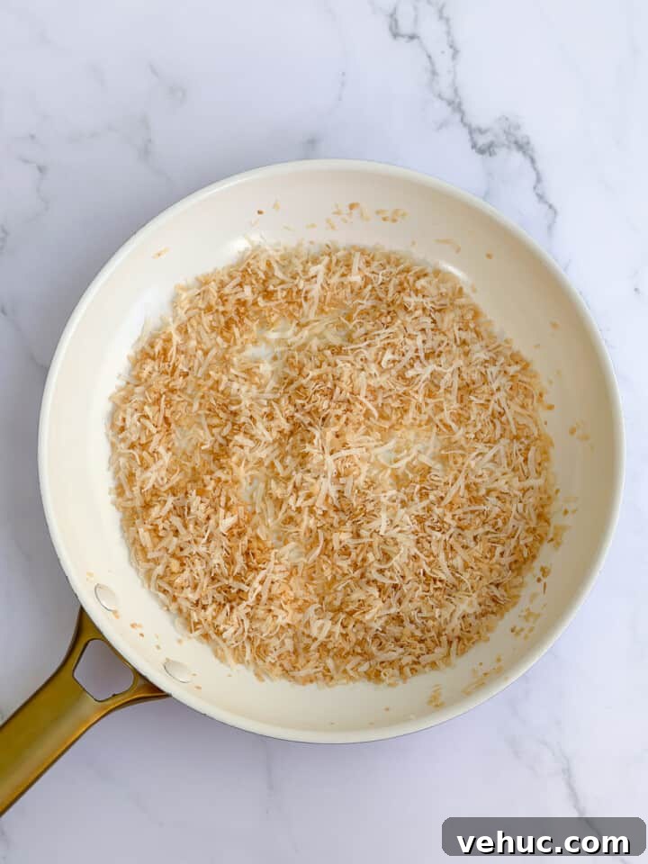 Moist Orange Coconut Cake Recipe with Zesty Glaze 11 coconut after being toasted.