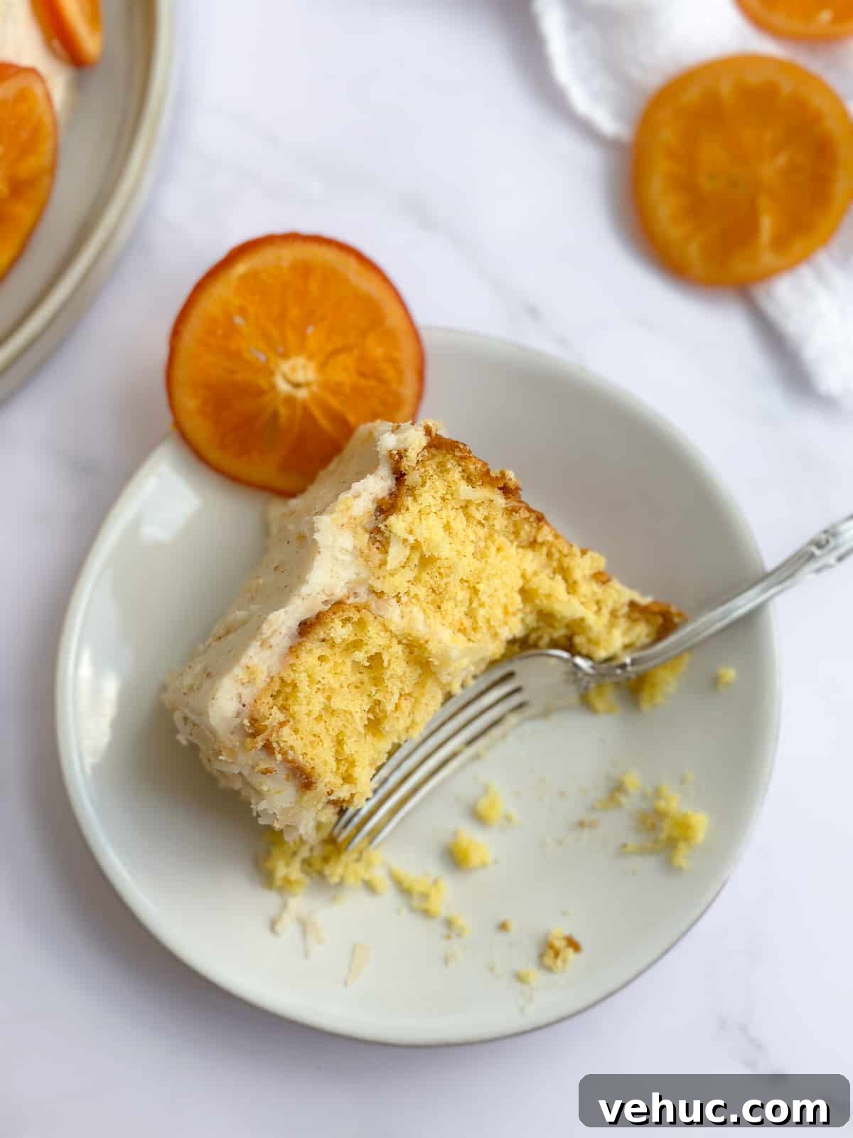 Moist Orange Coconut Cake Recipe with Zesty Glaze 3 a slice of orange coconut cake with some bites missing.