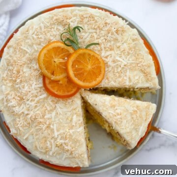 Moist Orange Coconut Cake Recipe with Zesty Glaze 24 a slice of orange coconut cake sliced and the rest whole.