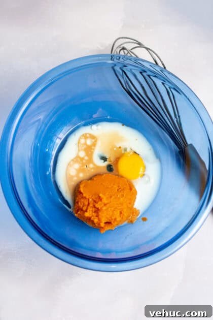 Pumpkin Spice Cake Donuts Recipe — Moist Fall Donut Tutorial 7 Mixing the wet ingredients together in a glass blue mixing bowl.