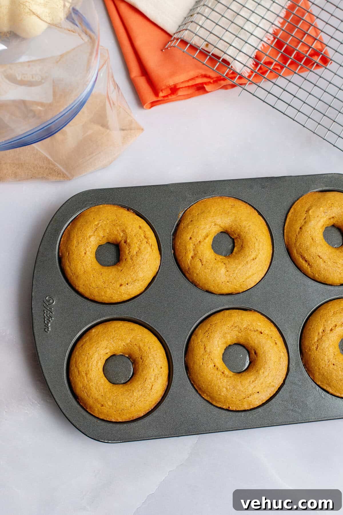 Pumpkin Spice Cake Donuts Recipe — Moist Fall Donut Tutorial 10 Pumpkin spice cake donuts fresh out of the oven in donut pan.