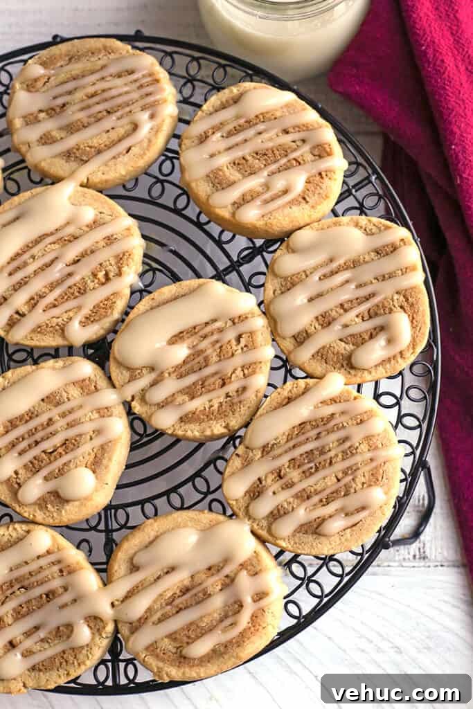 Paleo Cinnamon Roll Cookie Recipe — Soft, Low-Carb Treats 2 paleo cinnamon roll cookies with glaze on them