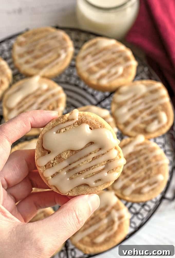 Paleo Cinnamon Roll Cookie Recipe — Soft, Low-Carb Treats 6 hand holding a paleo cinnamon roll cookie showing the top with icing
