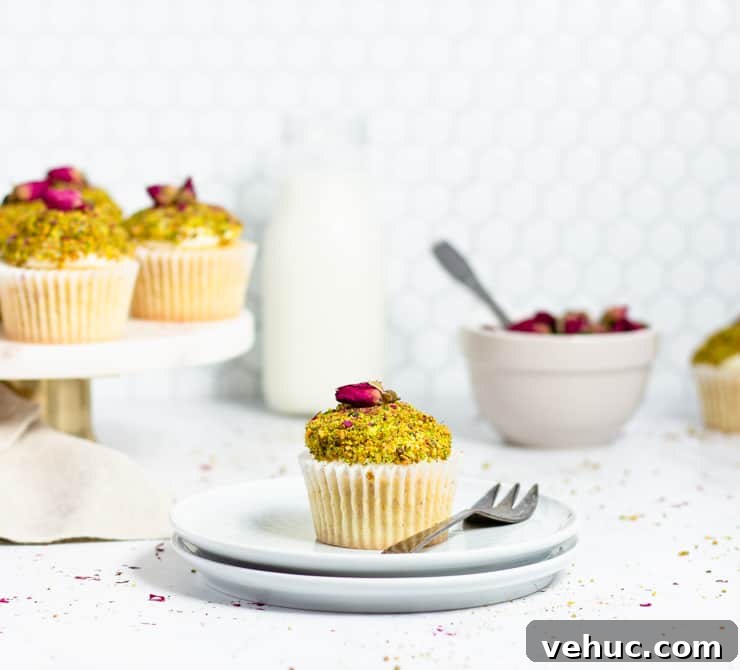 Persian Love Cake Cupcakes: Saffron Rose Water Dessert Recipe 2 cupcake on a plate with a bowl of rose buds and a jug of milk in the background